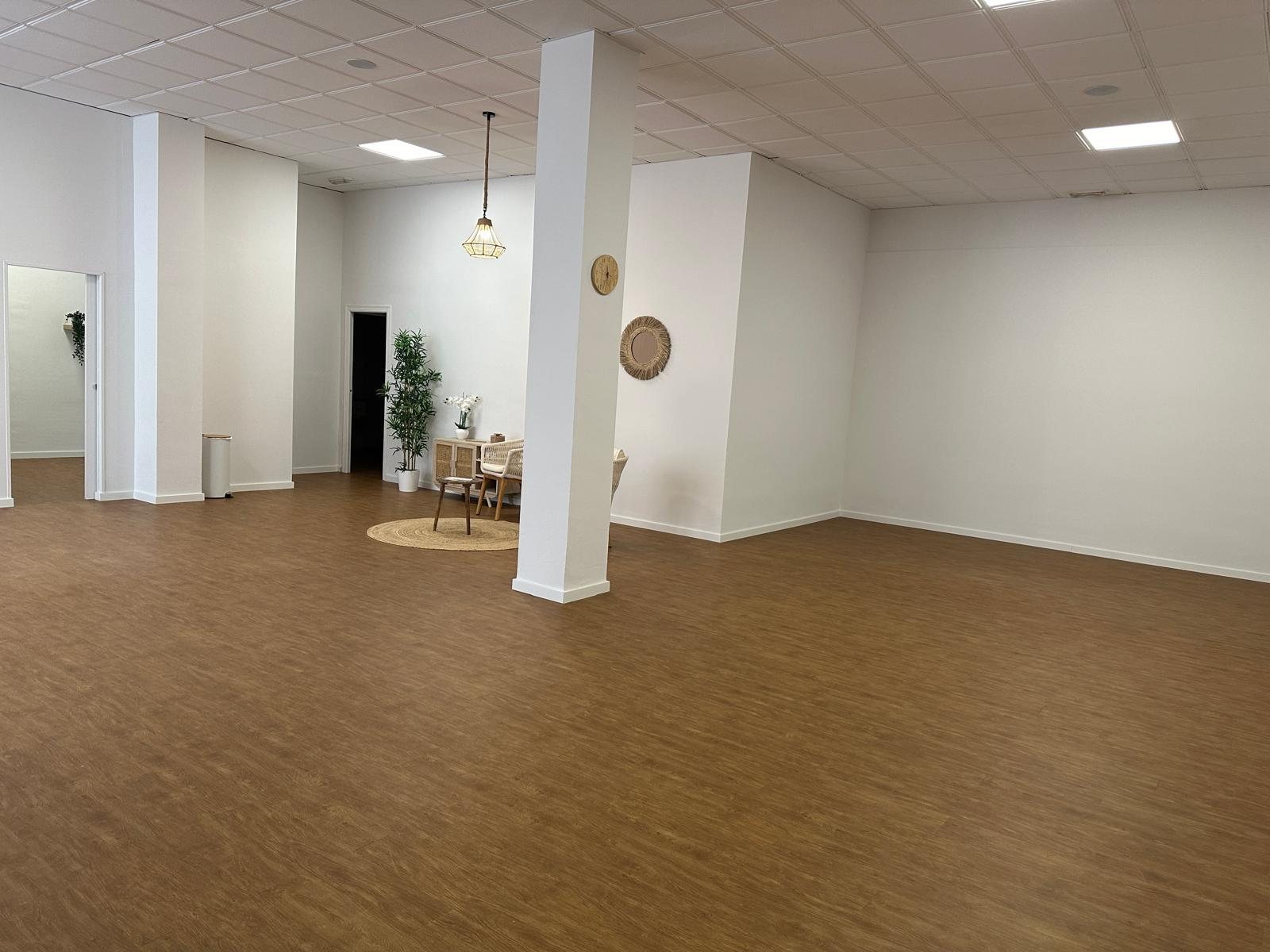 Sala diàfana de 100 m² amb terra de fusta, buida i a punt per a una classe